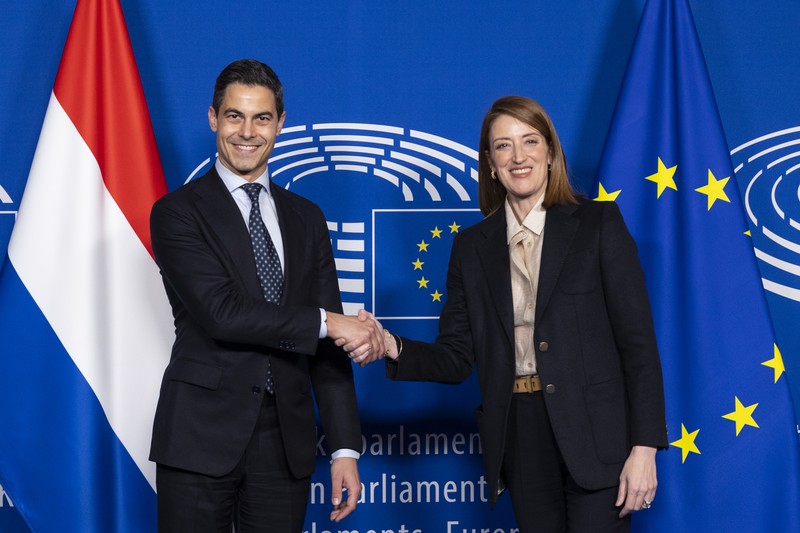 Dutch Prime Minister Rob Jetten shakes hands with European Parliament President Roberta Metsola, with Dutch and EU flags visible
