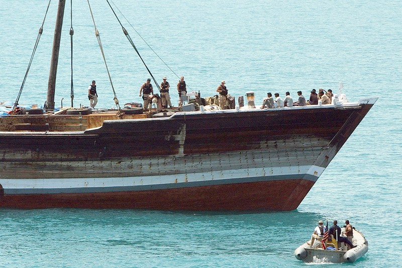 U.S. Navy security force boarding team inspects a merchant ship in the Arabian Gulf from a rigid-hulled inflatable boat