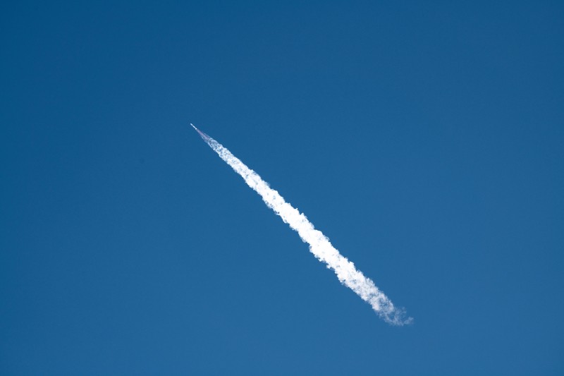 A New Glenn rocket launches from Space Launch Complex 36 at Cape Canaveral Space Force Station, leaving a bright exhaust trail against a blue sky