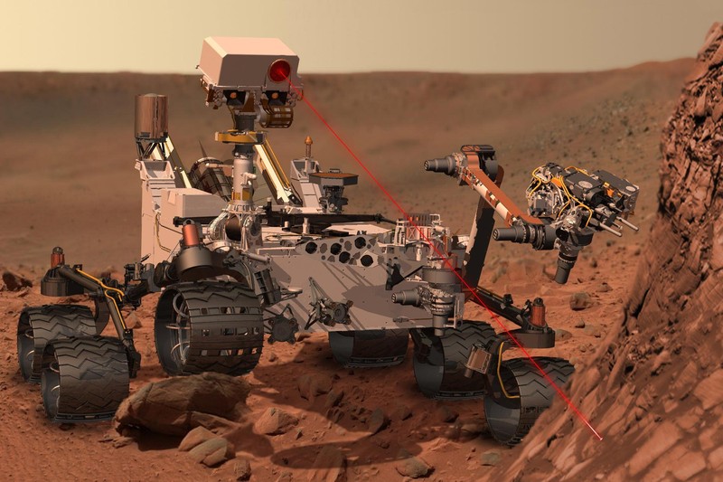 Artist's concept of NASA's Curiosity rover using its ChemCam laser instrument to analyze the composition of a rock on the Martian surface