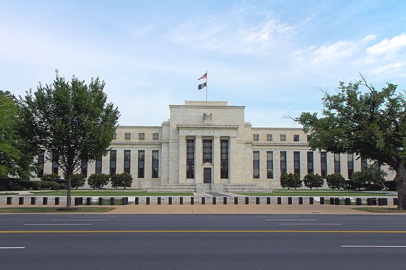 The Marriner S. Eccles Federal Reserve Building in Washington, D.C., with an American flag flying atop the central entrance