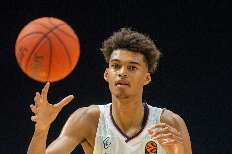 Victor Wembanyama in a white basketball jersey handling the ball during a game