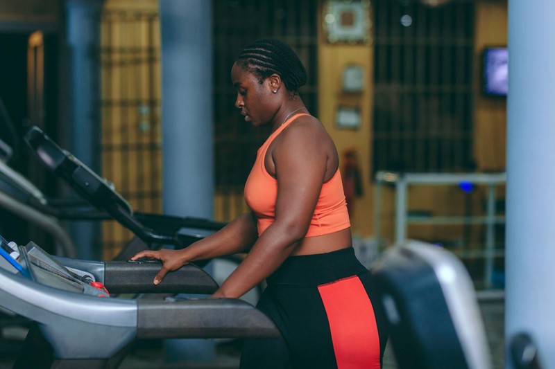 A focused woman running on a treadmill in a modern gym