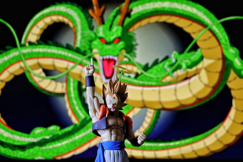 A Dragon Ball Super Saiyan action figure posing with Shenron the dragon coiled behind against a dark background