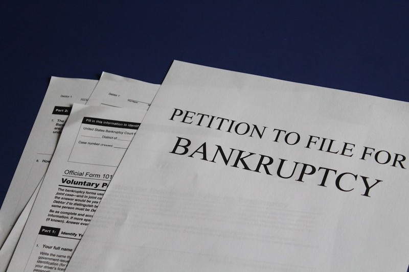 Stack of bankruptcy petition documents on a dark blue background