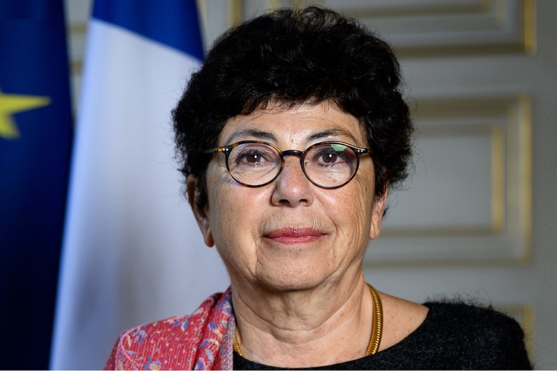 Official portrait of a French government official flanked by French and EU flags