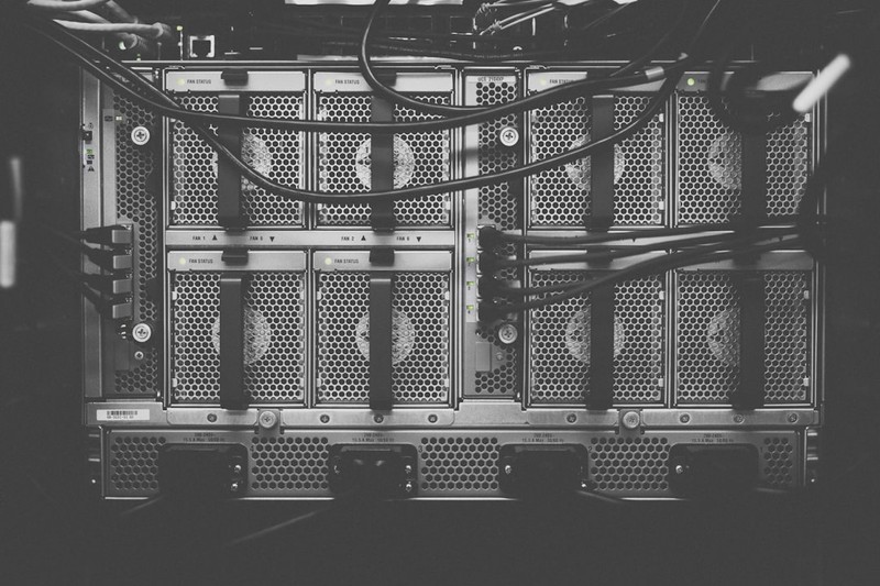 Black-and-white close-up of a server rack with cables in a data center