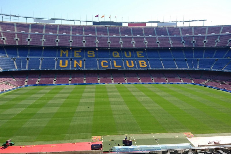 Panoramic view of Camp Nou stadium in Barcelona with empty stands and the motto 'Més Que Un Club' visible on the seats