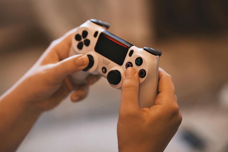 Close-up of hands holding a white gaming controller