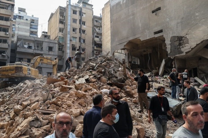 Aftermath of a 2024 Israeli airstrike in Lebanon showing destroyed buildings and rubble being cleared by an excavator