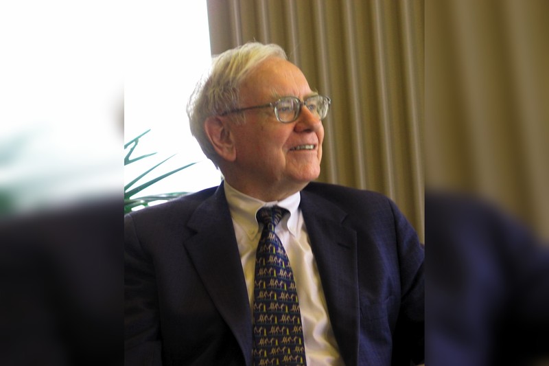 Warren Buffett in a professional portrait, smiling warmly in a business setting