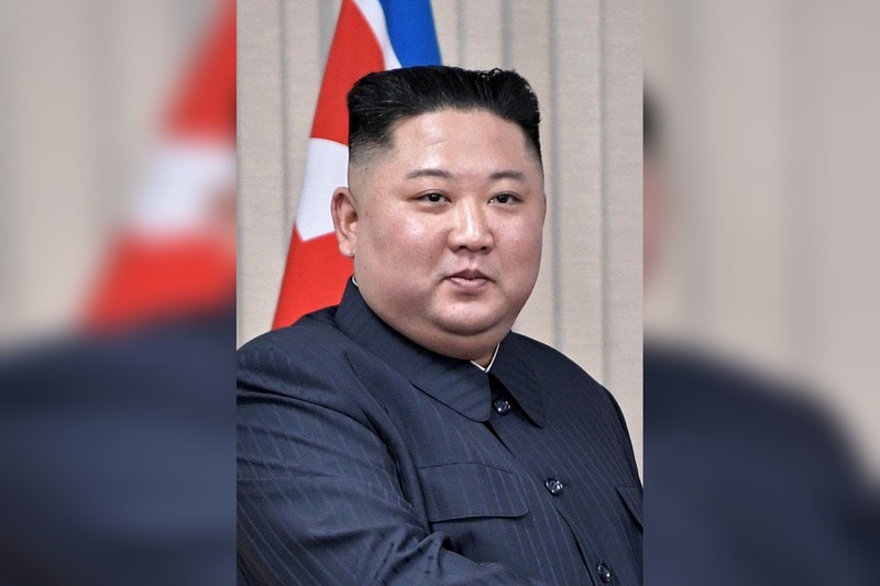Kim Jong-un seated before a North Korean flag during negotiations in Vladivostok, Russia