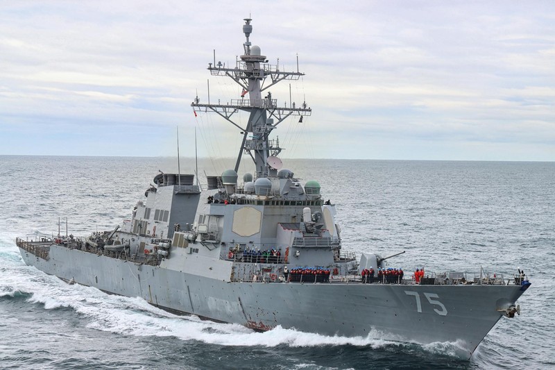 A US Navy guided-missile destroyer underway in open ocean under a cloudy sky
