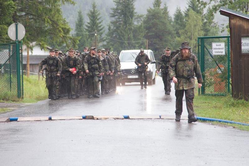 Soldiers from the 18th Military Police Brigade and Bundeswehr march along a wet road during a joint military exercise in Germany