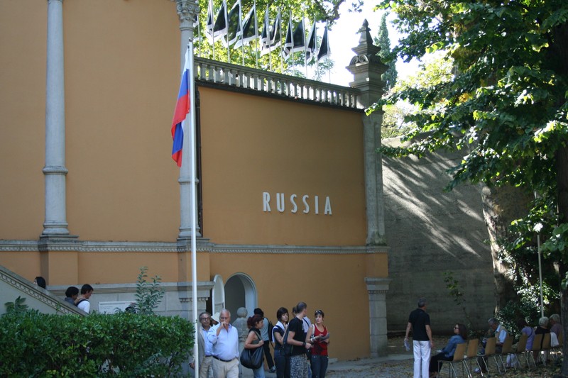 The Russian Pavilion in the Venice Biennale Gardens, with Russia signage and flag visible on the ornate facade