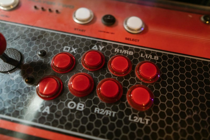 Close-up of a red and black arcade fight stick controller with joystick and glossy action buttons