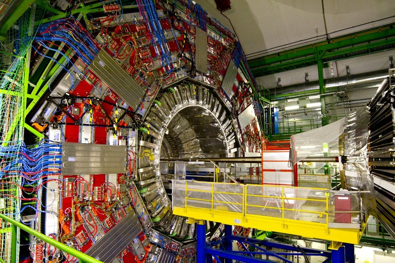 Close-up view inside CERN's Large Hadron Collider showing colorful cables and detector components