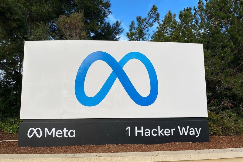 Meta headquarters entrance sign displaying the company logo and address at 1 Hacker Way, Menlo Park, California