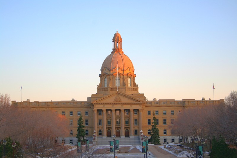 The Alberta Legislature Building in Edmonton under golden-hour light with snow on the ground