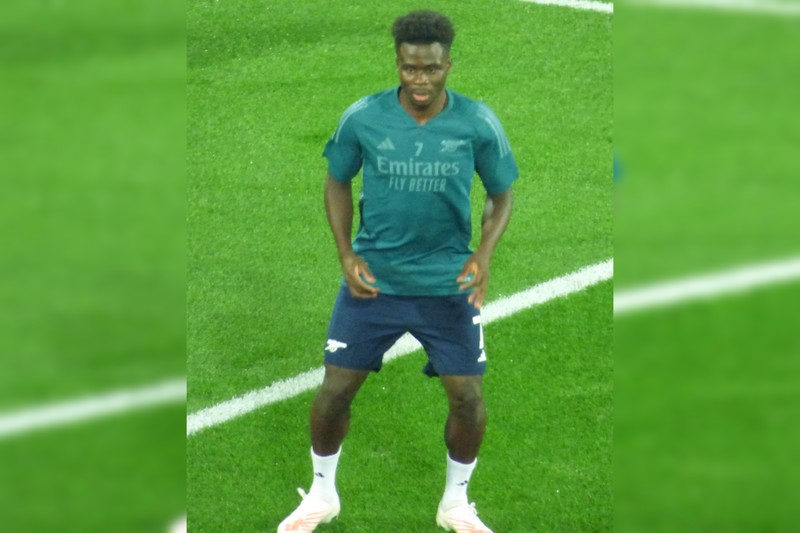 Bukayo Saka in Arsenal kit on a football pitch