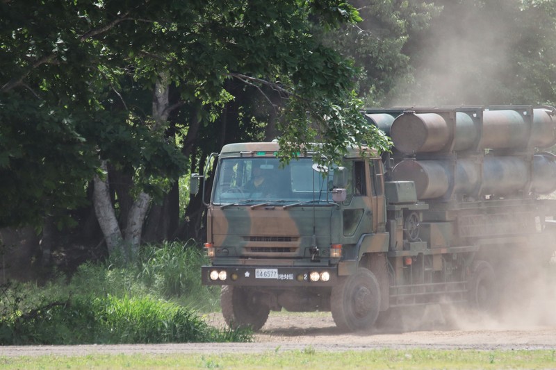 Japanese Type 88 surface-to-ship missile launcher traveling on a dirt road through a forested area