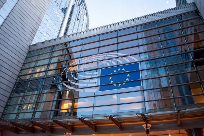 The European Parliament building in Brussels with EU flag displayed on its glass facade