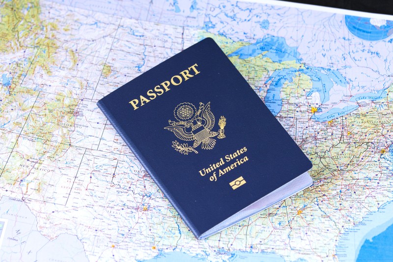 A United States passport resting on a detailed map of the United States