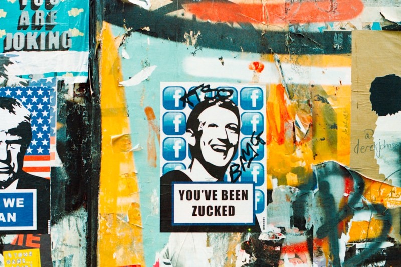 Street art sticker on a London wall showing a caricature of Mark Zuckerberg with the text 'You've Been Zucked' surrounded by Facebook logo icons
