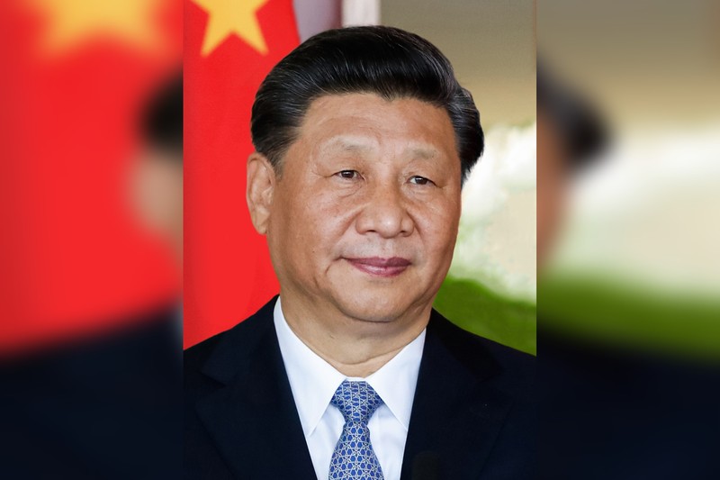 Xi Jinping, General Secretary of the Chinese Communist Party, poses in front of the Chinese national flag