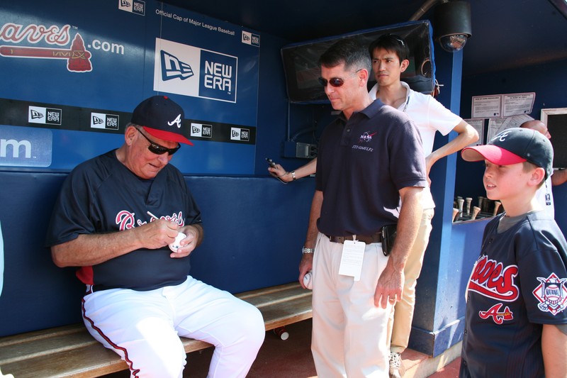 Atlanta Braves manager Bobby Cox signs a baseball in the dugout before a game at Turner Field