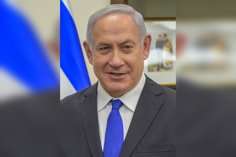 Benjamin Netanyahu, Prime Minister of Israel, in an official portrait with the Israeli flag visible in the background