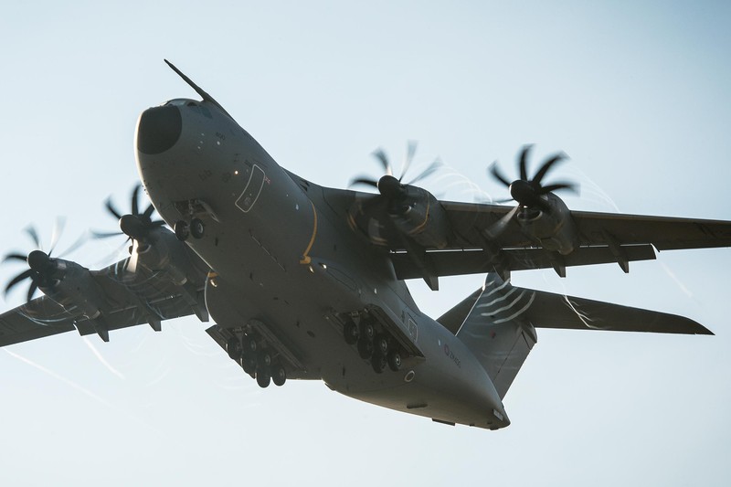 A Royal Air Force A400M Atlas military transport aircraft flying against a clear blue sky