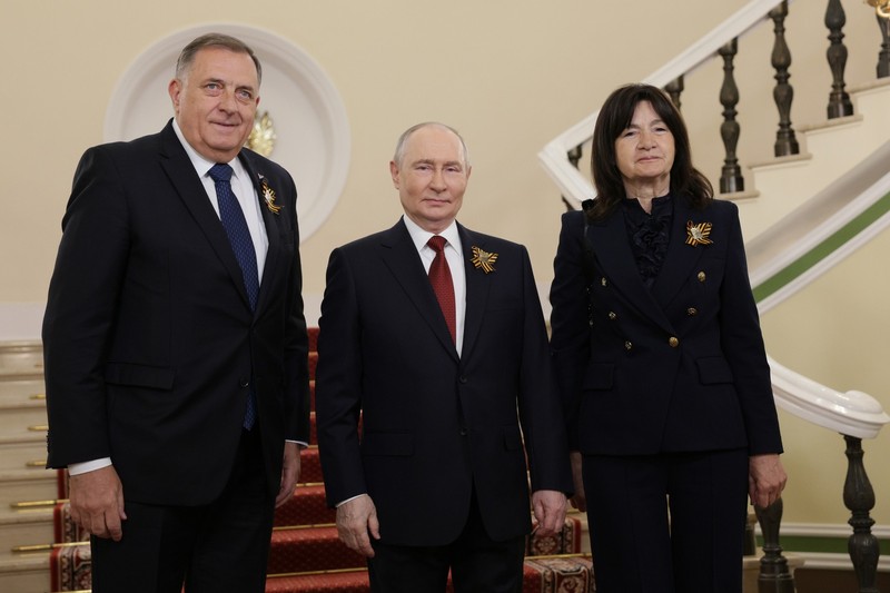 Russian President Vladimir Putin stands with foreign dignitaries in a formal diplomatic setting