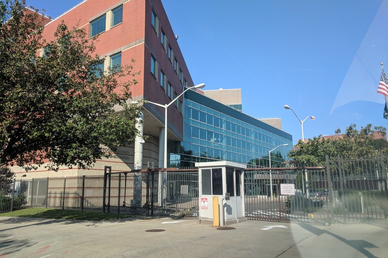 Exterior of a U.S. Food and Drug Administration office building with security gate and American flag
