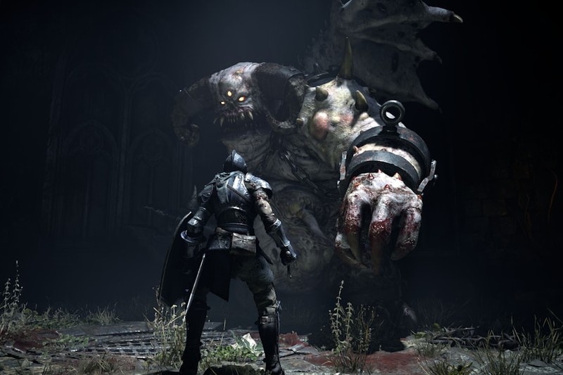 An armored warrior faces a towering grotesque monster in a dark cave