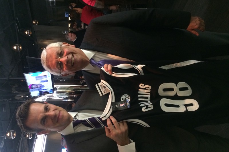 A black Brooklyn Nets basketball jersey with the name Collins and number 98 held up during a press event
