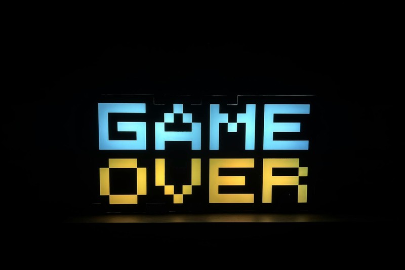 Pixel art style GAME OVER sign in blue and yellow on black background
