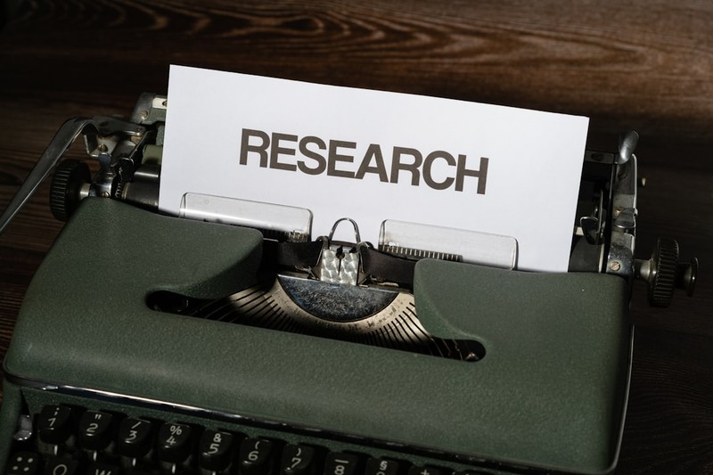 A vintage typewriter with the word RESEARCH typed on a sheet of paper