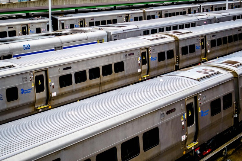 Aerial view of silver LIRR commuter trains parked in a rail yard on parallel tracks