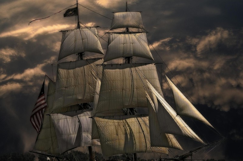 A majestic multi-masted sailing ship with white sails billowing against a dramatic stormy sky