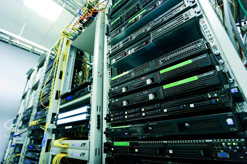 Server racks in a high-tech data center with network cables and hardware components, shot from a low angle emphasizing scale.
