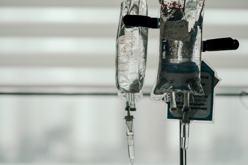 Intravenous fluid bags hanging on a medical stand in a clinical setting