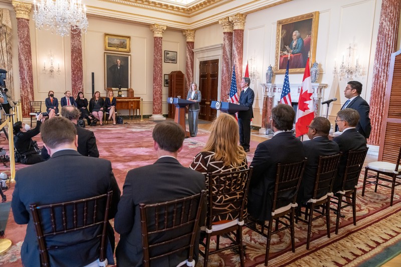 U.S. Secretary of State Antony Blinken and Canadian Foreign Minister Mélanie Joly at a joint press conference with U.S. and Canadian flags