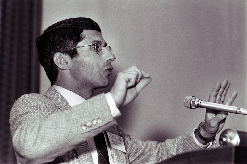 Dr. Anthony Fauci delivering a talk at a podium in 1985