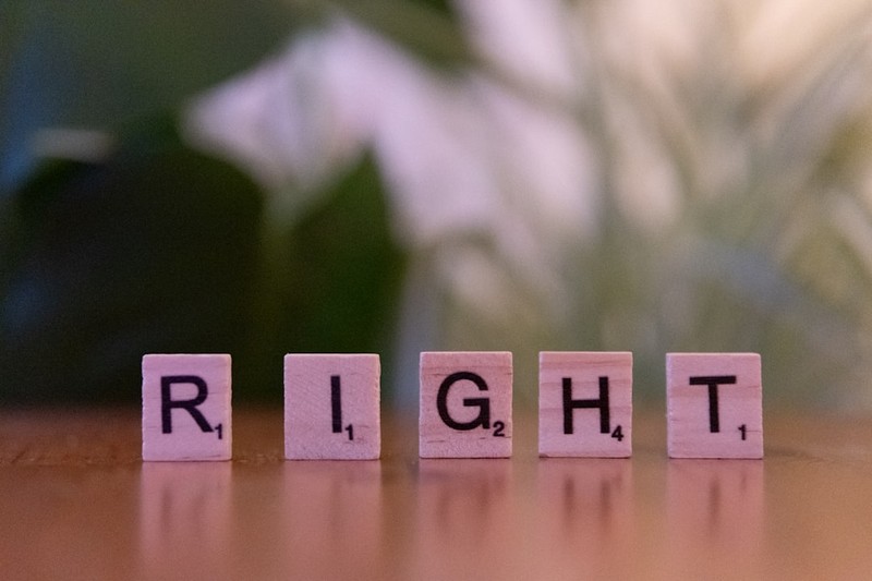 Scrabble tiles spelling the word RIGHT on a wooden surface