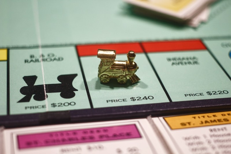 A golden Monopoly train token on a game board property space