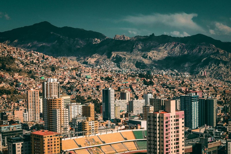 Aerial view of La Paz, Bolivia nestled in the Andes mountains with dense urban architecture and a prominent stadium
