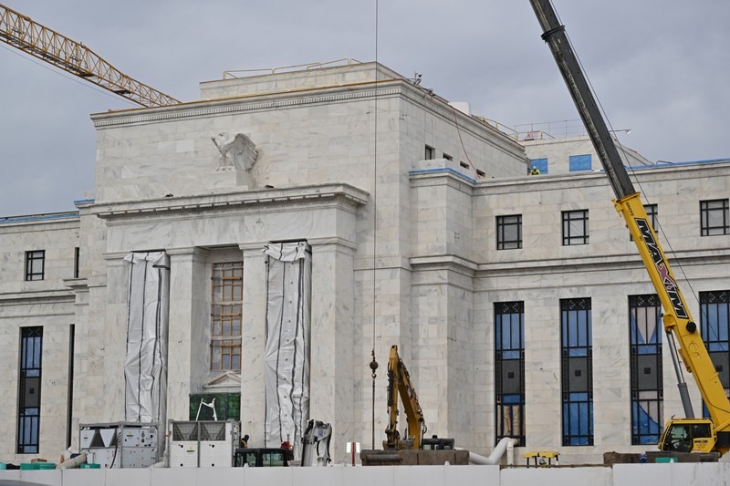 The Marriner S. Eccles Federal Reserve headquarters building in Washington, D.C., surrounded by construction equipment during ongoing renovation.