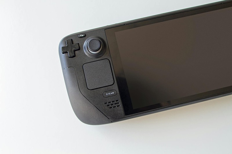 A Steam Deck handheld gaming console shown on a white background, displaying its controller layout and Steam branding