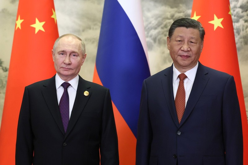 Vladimir Putin and Xi Jinping standing side by side during a state visit in Beijing